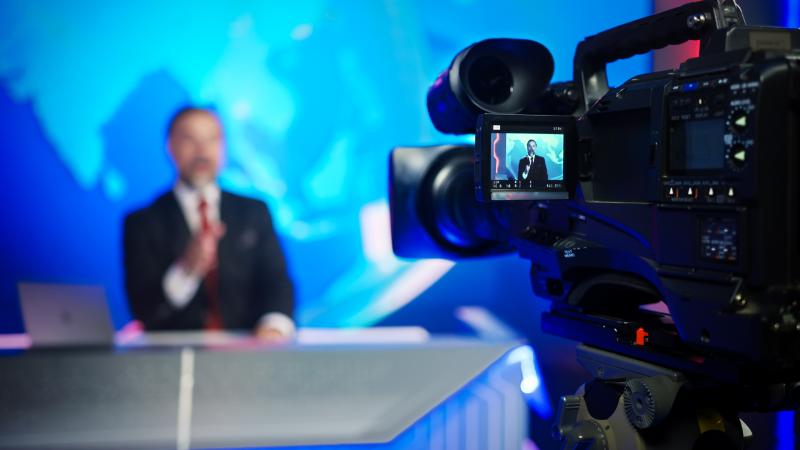 tv news anchorman at his desk