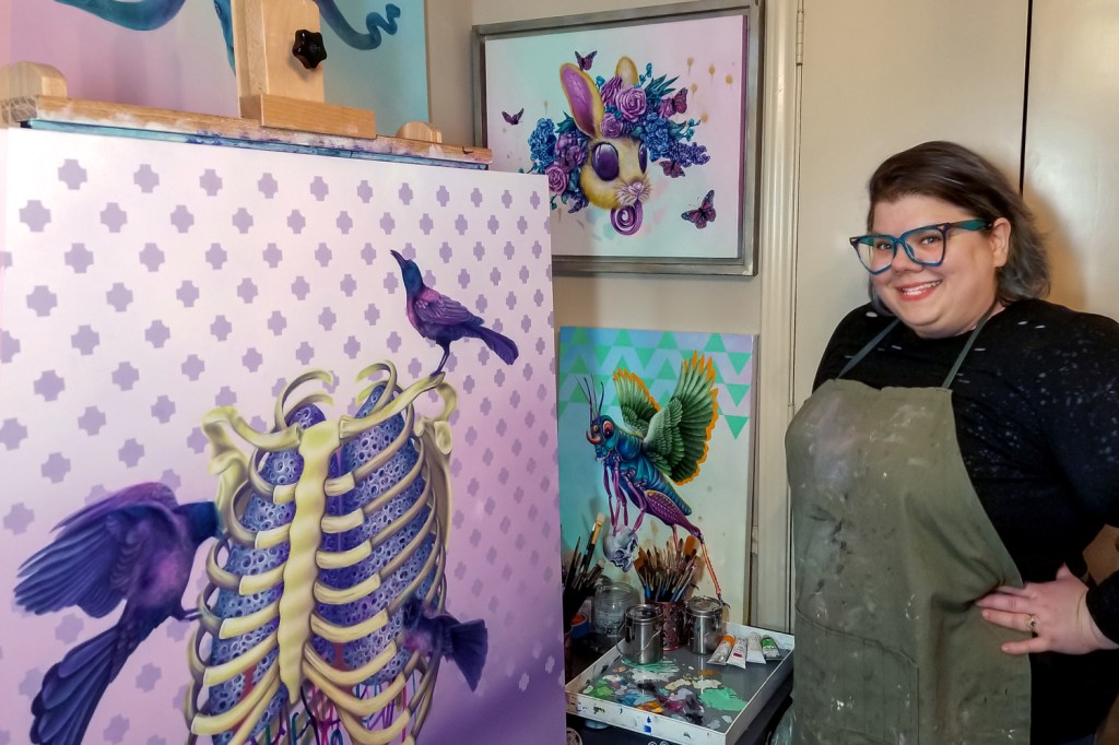Artist Holli Michener with paintings in her studio.
