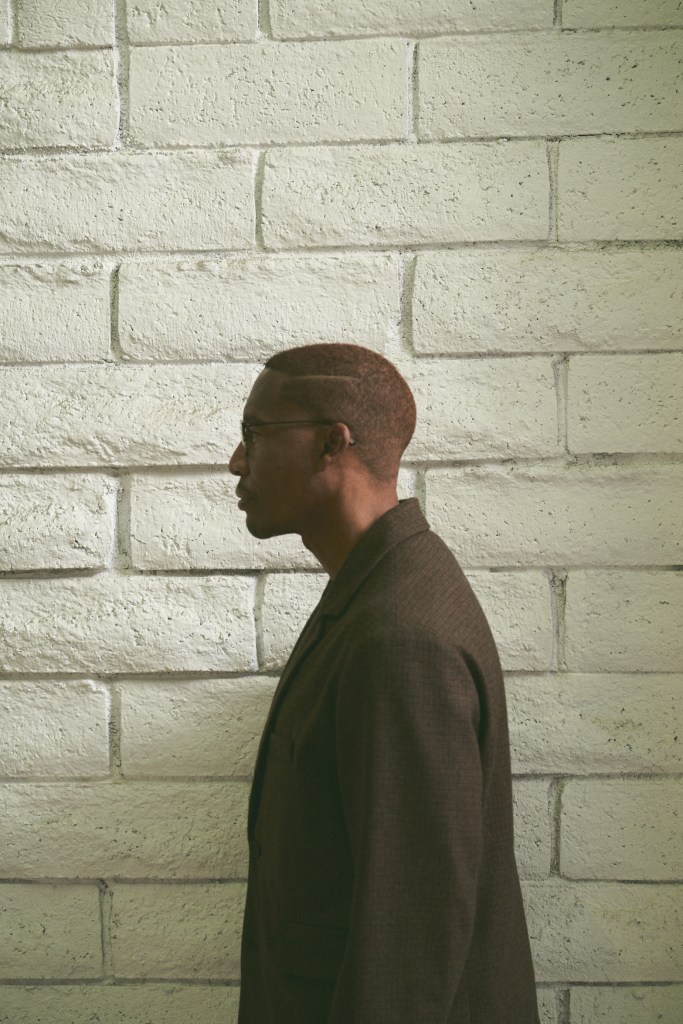 Man posing in front of bricks