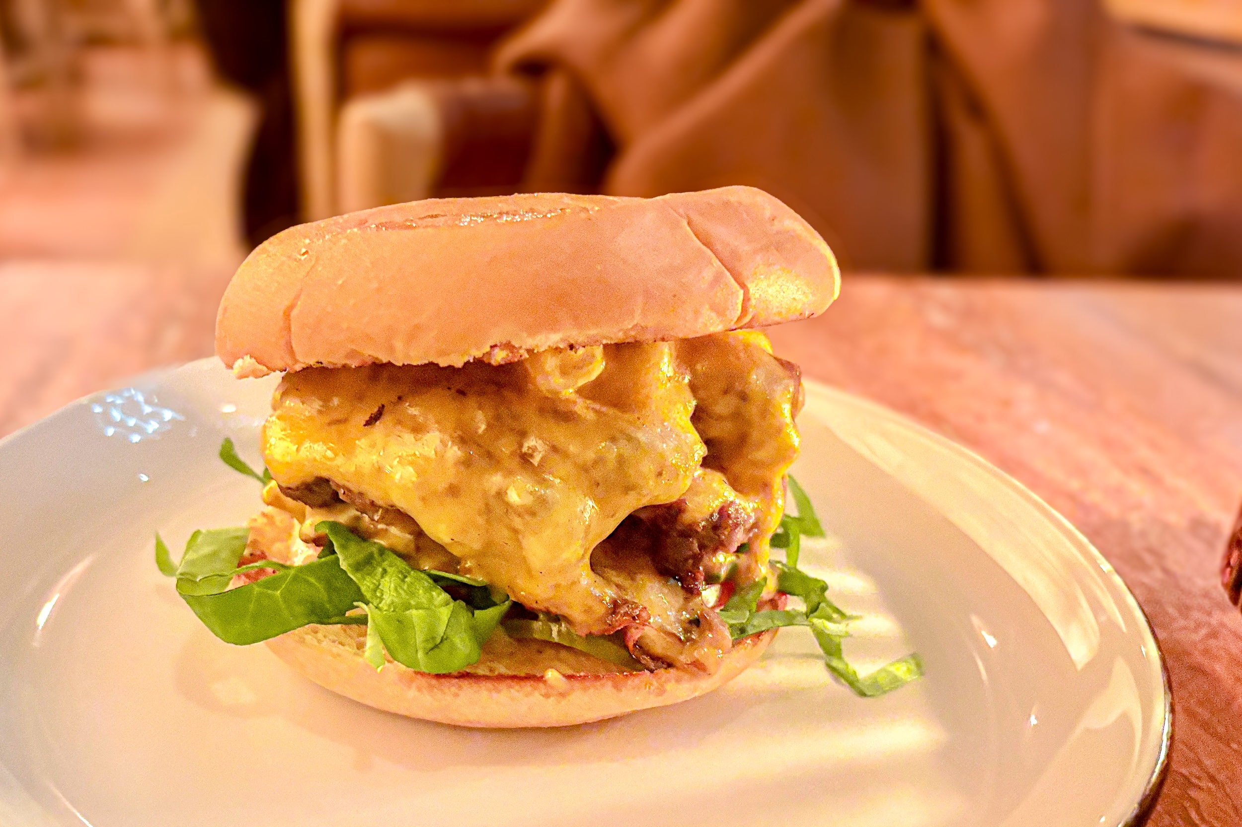 A Little Ruby's Burger sitting on a plate on a table