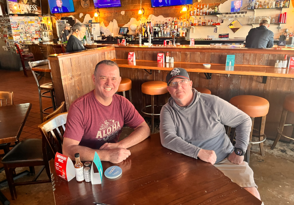 The Pour House's owners, Tim Feutz and Calvin Bow, sit at a table in the bar.