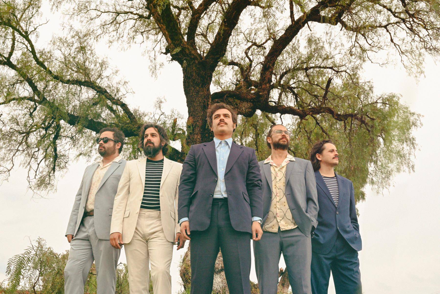 indie-rock band Enjambre stands in front of trees