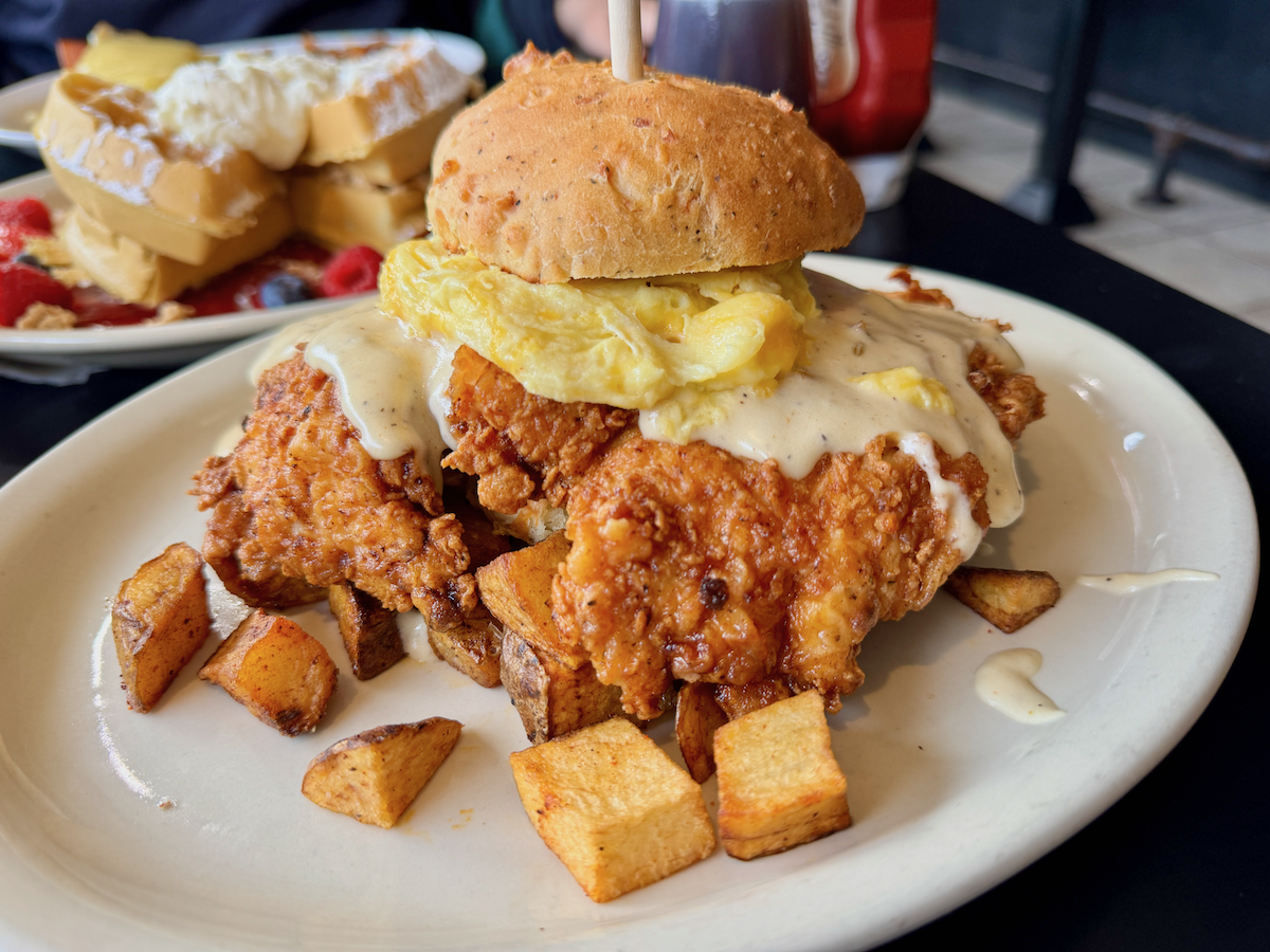 A huge chicken and biscuit sandwich on a plate.