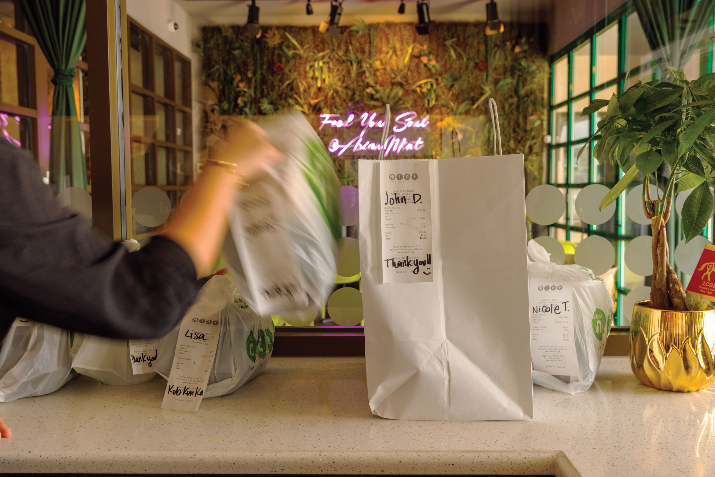 take out bags sitting on a counter, one is being removed.