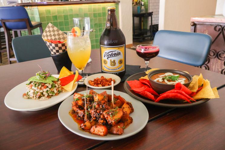 a table filled with botanas and mexican drinks