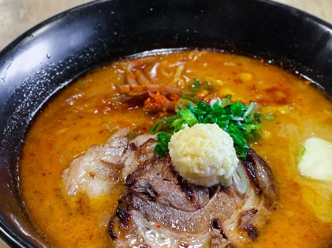 spicy miso ramen in a bowl served with two thick slices of pork belly at Ichigoh.