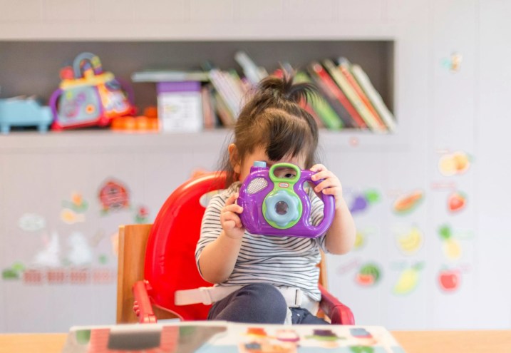 A girl in a daycare class plays with a toy.