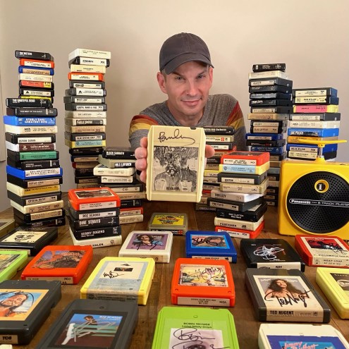 Jason Niebaum shows off his signed collection of 8-track tapes, which keeps growing one concert at a time.