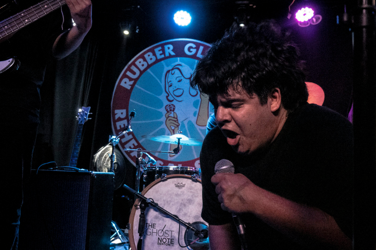A man from a band screaming into a microphone