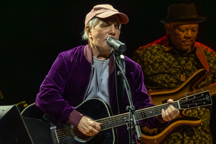 Man performing on stage with a guitar
