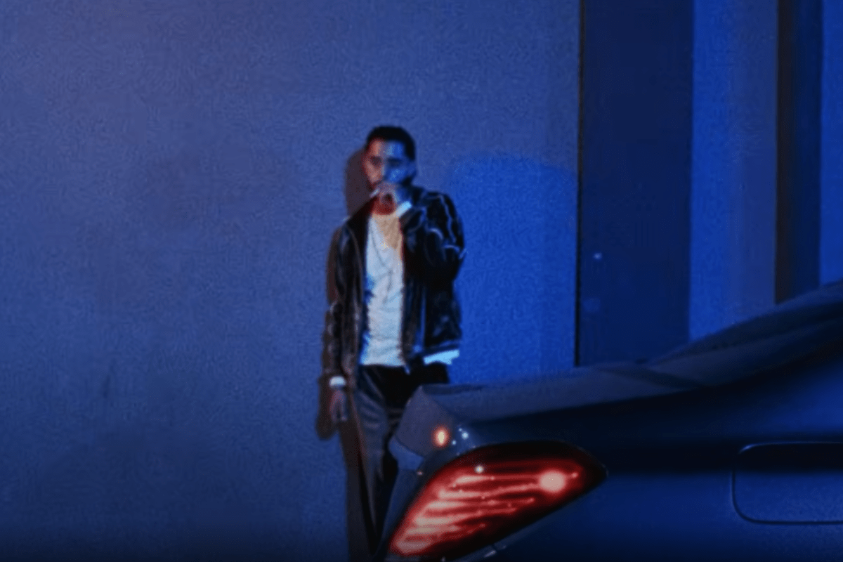 Man smoking in front of car