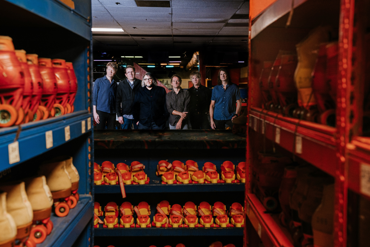 A group of guys posed near rollerskates