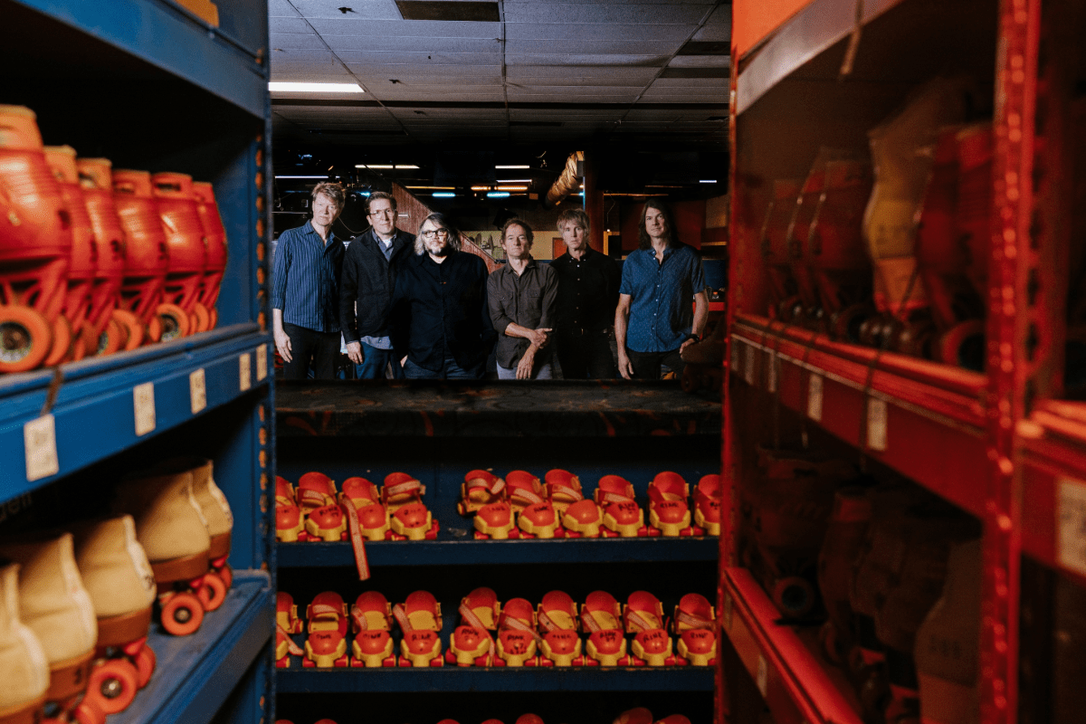 A group of guys posed near rollerskates