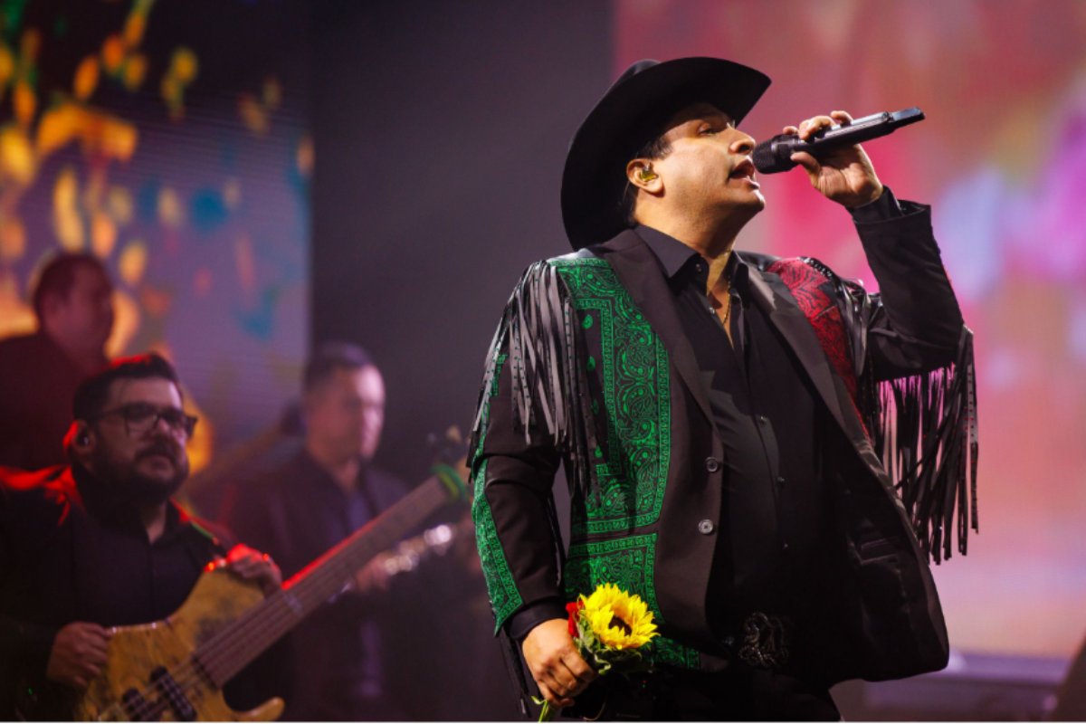 Man on stage performing with his band