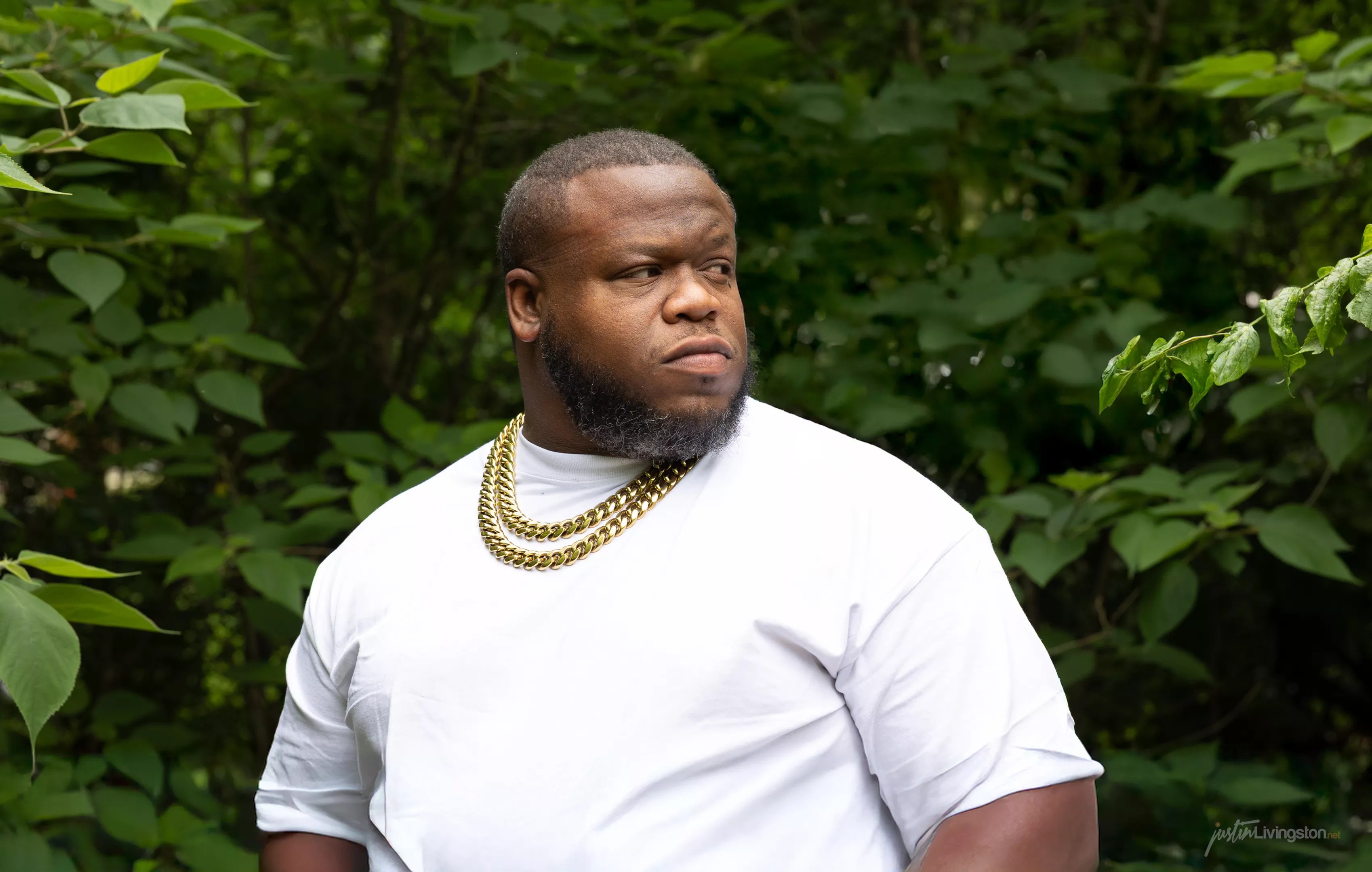 Man posing behind a tree