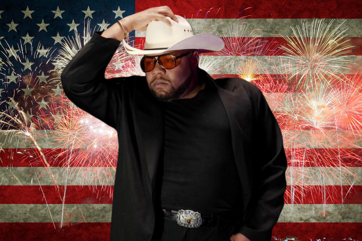 Man standing in front of an American flag with a cowboy hat