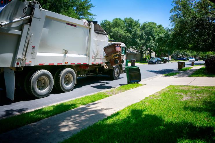 trash truck picking up in a neighborhood